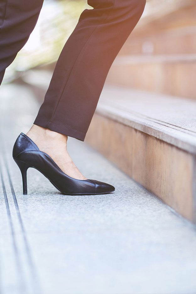 close up of foot of woman wearing heels climbing up stairs