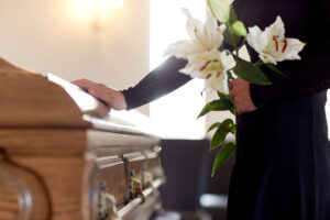 woman with white lilies at coffin