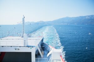 ferry with wake trailing behind it in the water