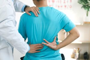 doctor helping patient with back pain